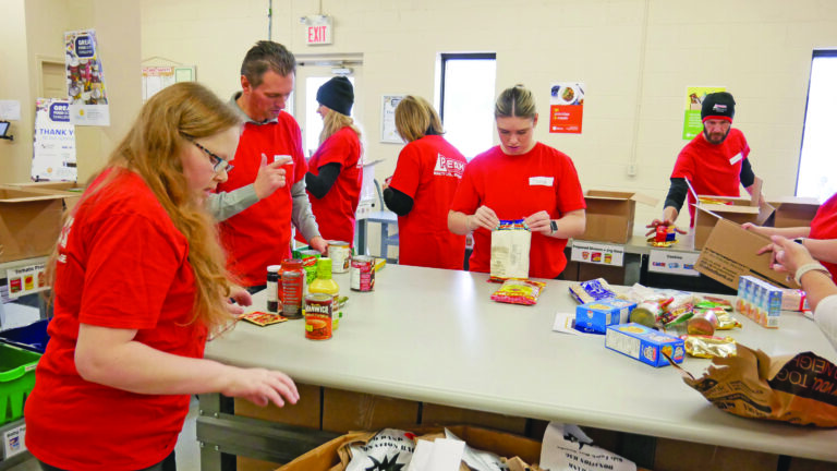 Peak Realty team unloading and sorting non-perishable food.