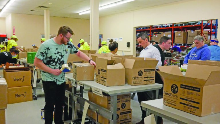 Kitchener Hyundai team sorting and taping up boxes full of non-perishable food.