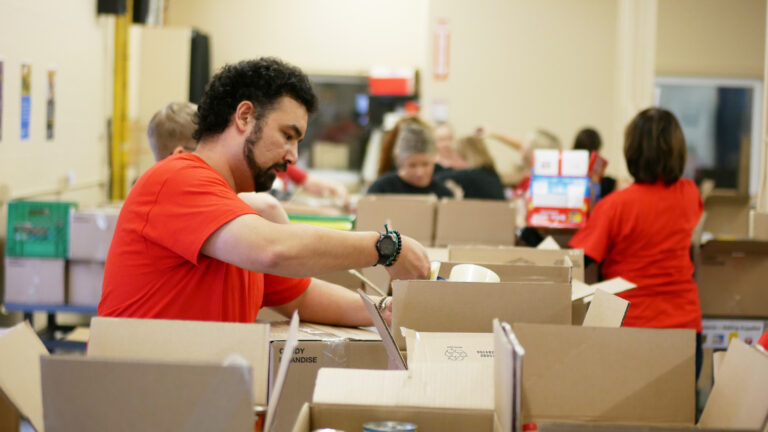 WalterFedy team taping up boxes full of non-perishable food.