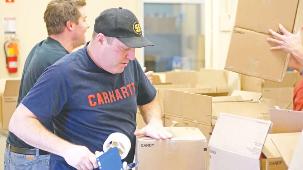 Steed and Evans team taping boxes full of non-perishable food.
