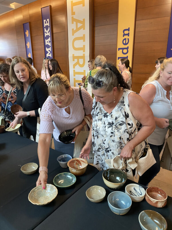 Empty Bowls 2023 - Two people selecting their bowls.