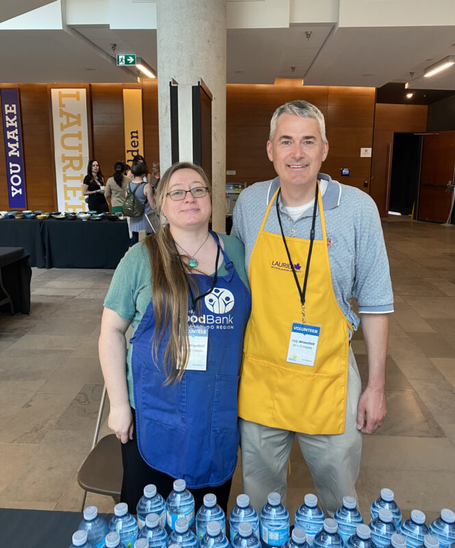 Empty Bowls 2023 - Two volunteers standing side-by-side smiling at camera.