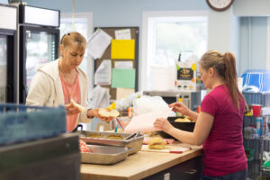 Louise preparing food with another volunteer.