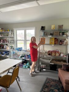 Christa Gerber placing food on the shelves.
