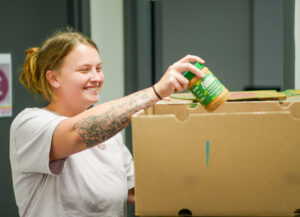 SASC staff unpacking peanut butter from The Food Bank